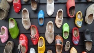 a bunch of wooden shoes that are hung on a wall